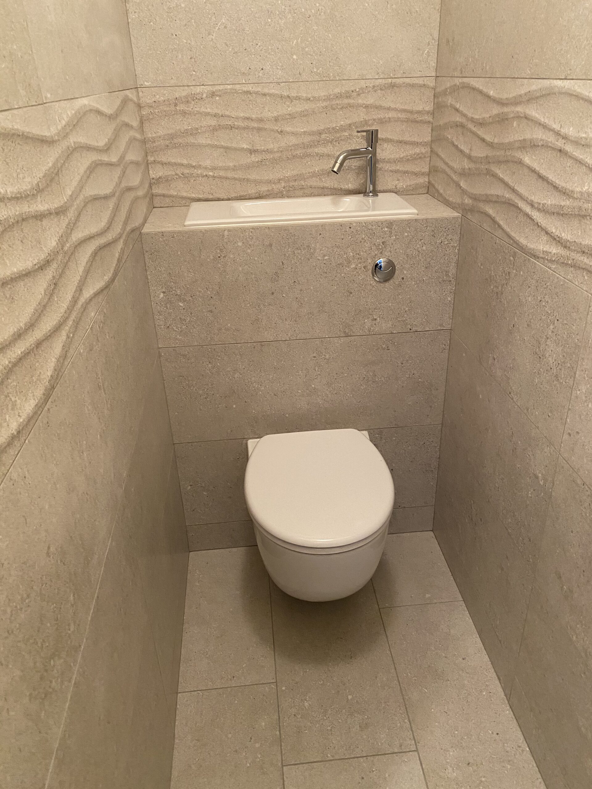 WC suspendu Geberit à Orvault avec lave-mains intégré et carrelage structuré ondulé beige
